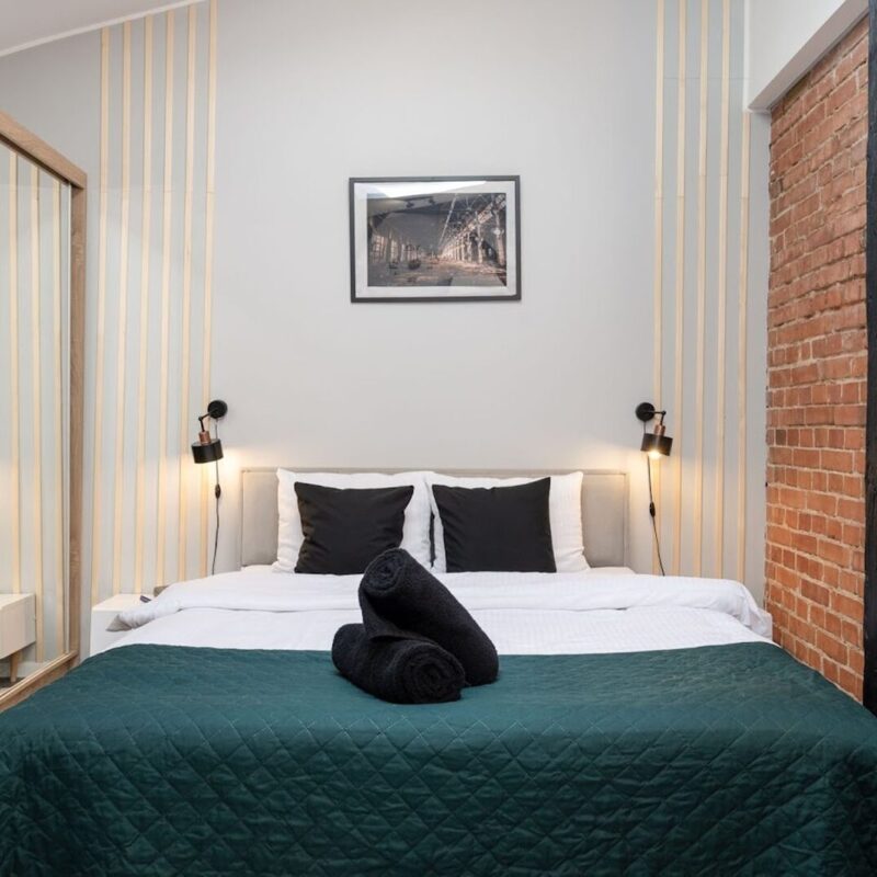 Sypialnia w stylu loft z ceglaną ścianą