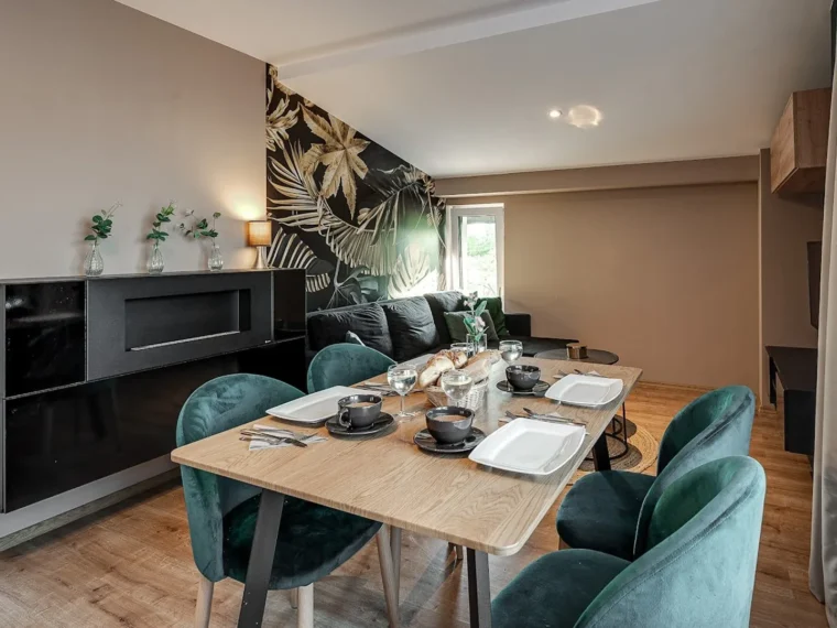 Apartament Kwadratowo, salon z jadalnia i zielonymi fotelami